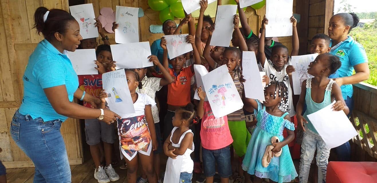 Niñas y niños presentan sus dibujos durante una actividad social de Fundación Aguaite